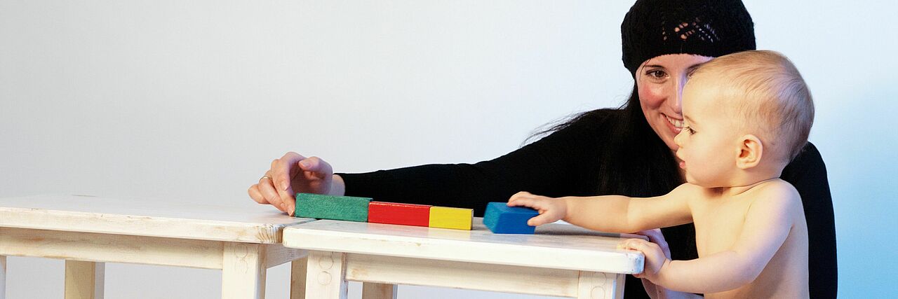 Mutter spielt mit Baby Eine Frau spielt mit einem nackten Baby