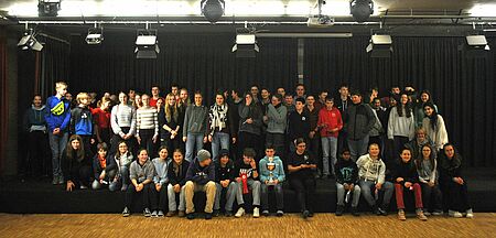 Ungefähr 60 Schulsanitäter und Schulsanitäterinnen stehe auf einer Bühne