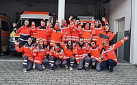 Die Teilnehmenden der Fachdienstausbildung stehen vor Einsatzfahrzeugen