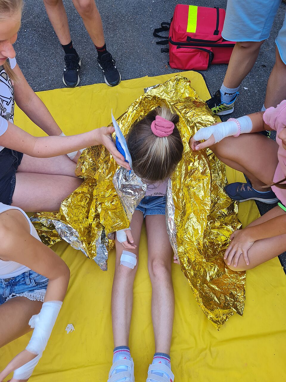 Juniorhelfer Eine Gruppe Juniorhelferinnen hilft einem verletzten Mädchen