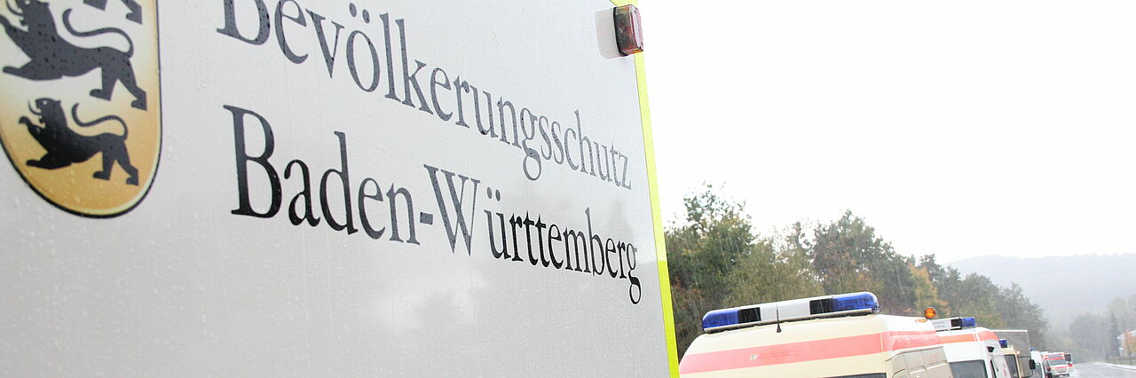 Bevölkerungsschutz Der Schriftzug "Bevökerungsschutz Baden-Württemberg" ist auf einem Einsatzfahrzeug im Regen zu sehen