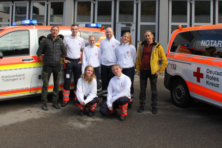 Die neuen Auszubildenden im Rettungsdienst stehen mit ihren Praxisanleitungen vor Notarzteinsatzfahrzeugen