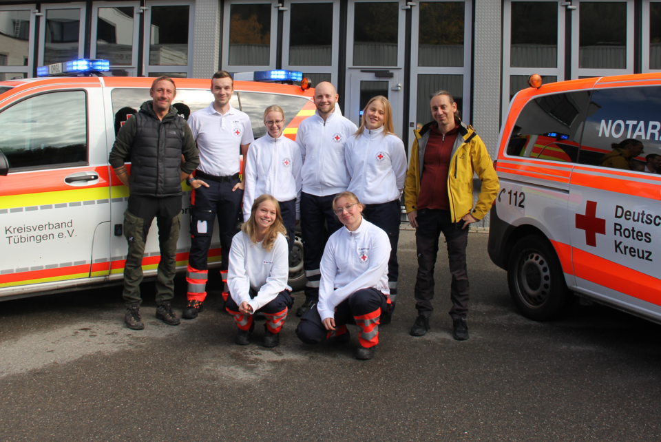 Die neuen Auszubildenden im Rettungsdienst stehen mit ihren Praxisanleitungen vor Notarzteinsatzfahrzeugen
