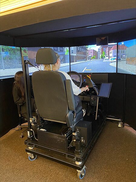 Eine unserer Auszubildenden sitzt an einem Fahrsimulator
