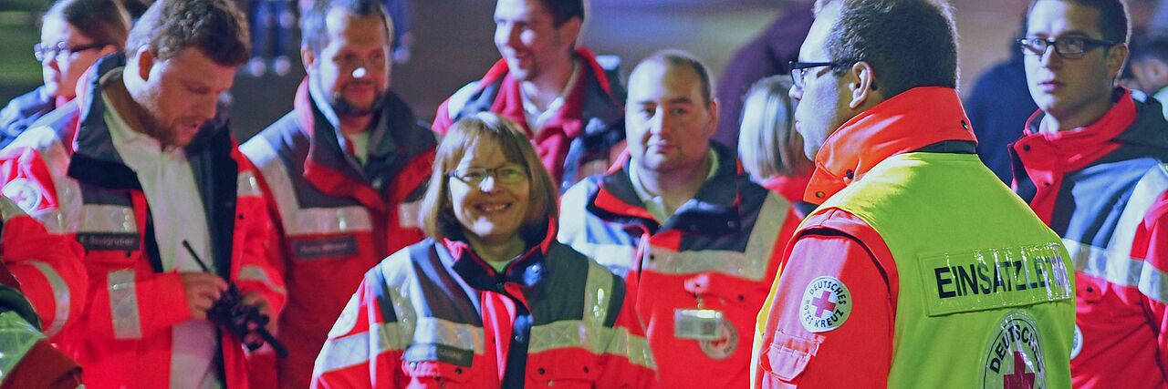 Ehrenamtliche Einsatzkräfte Einsatzkräfte des DRK bekommen Anweisungen von einem Einsatzleiter
